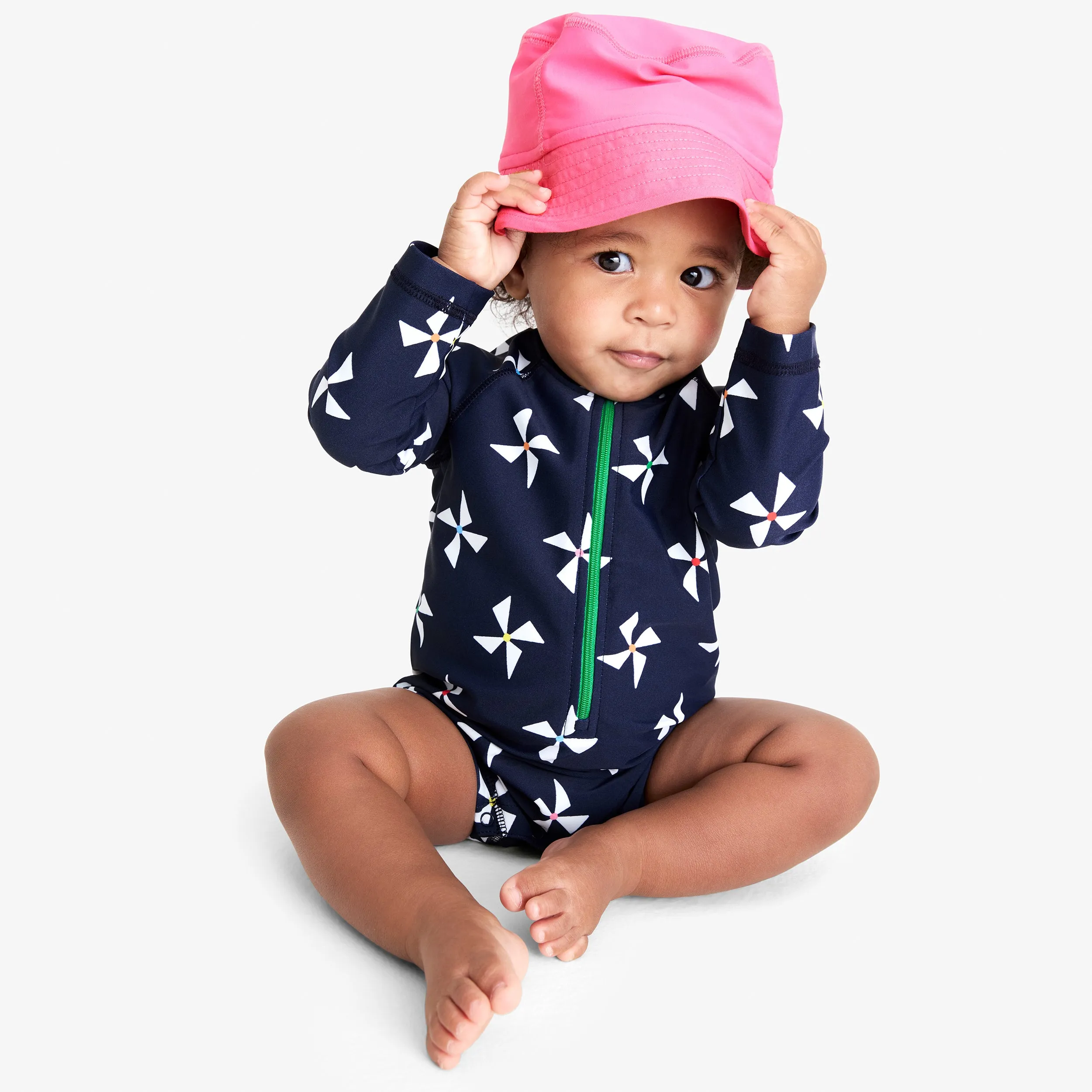 Baby one-piece rash guard in rainbow pinwheels