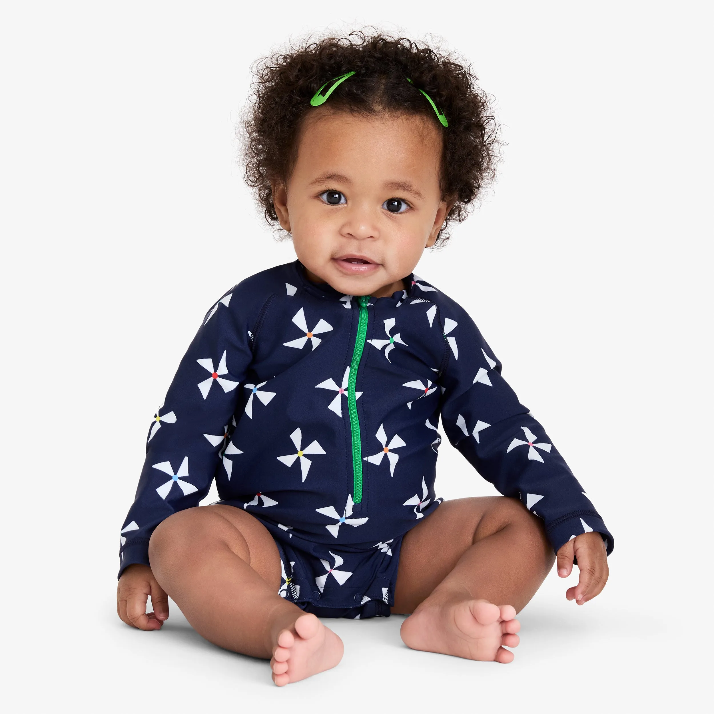 Baby one-piece rash guard in rainbow pinwheels